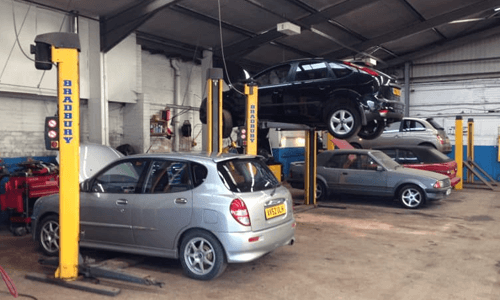 interiors of a garage with cars getting serviced
