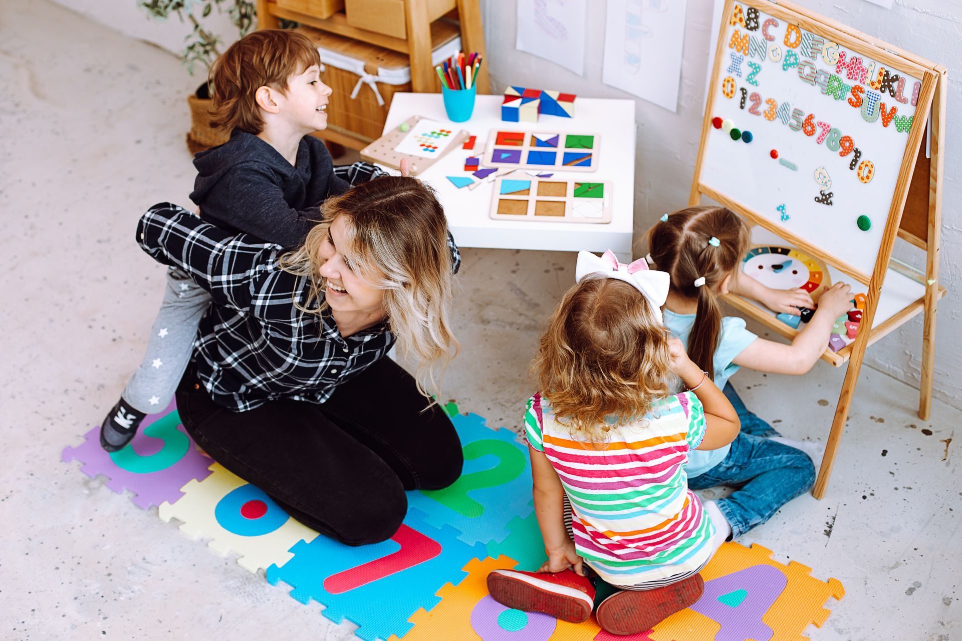 A teacher with children having fun and playing games, learning letters and numbers.