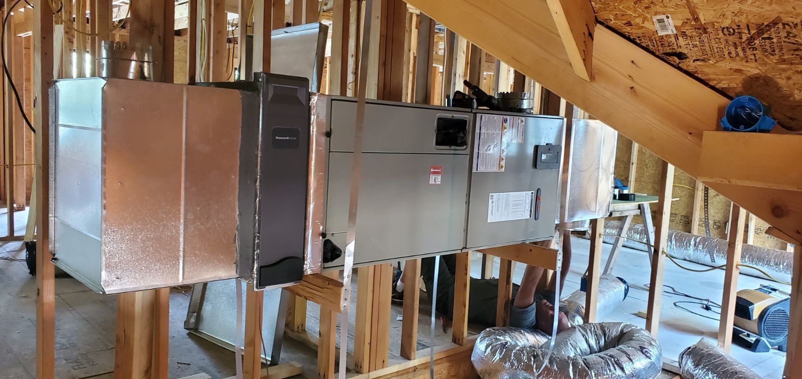 A room in a house under construction with a staircase.