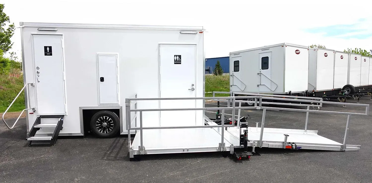 Exterior of white luxury restroom trailer with deck and railing for premium portable toilet rental services in Orange County. Exterior of white luxury restroom trailer with deck and railing for premium portable toilet rental services in Orange County.