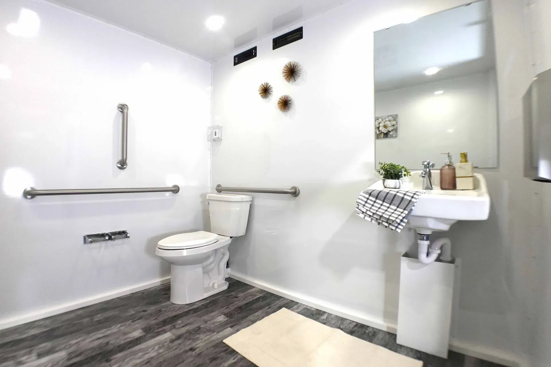 High-end mobile restroom trailer bathroom with toilet, sink, mirror, and elegant décor for luxury porta potty rentals. High-end mobile restroom trailer bathroom with toilet, sink, mirror, and elegant décor for luxury porta potty rentals.