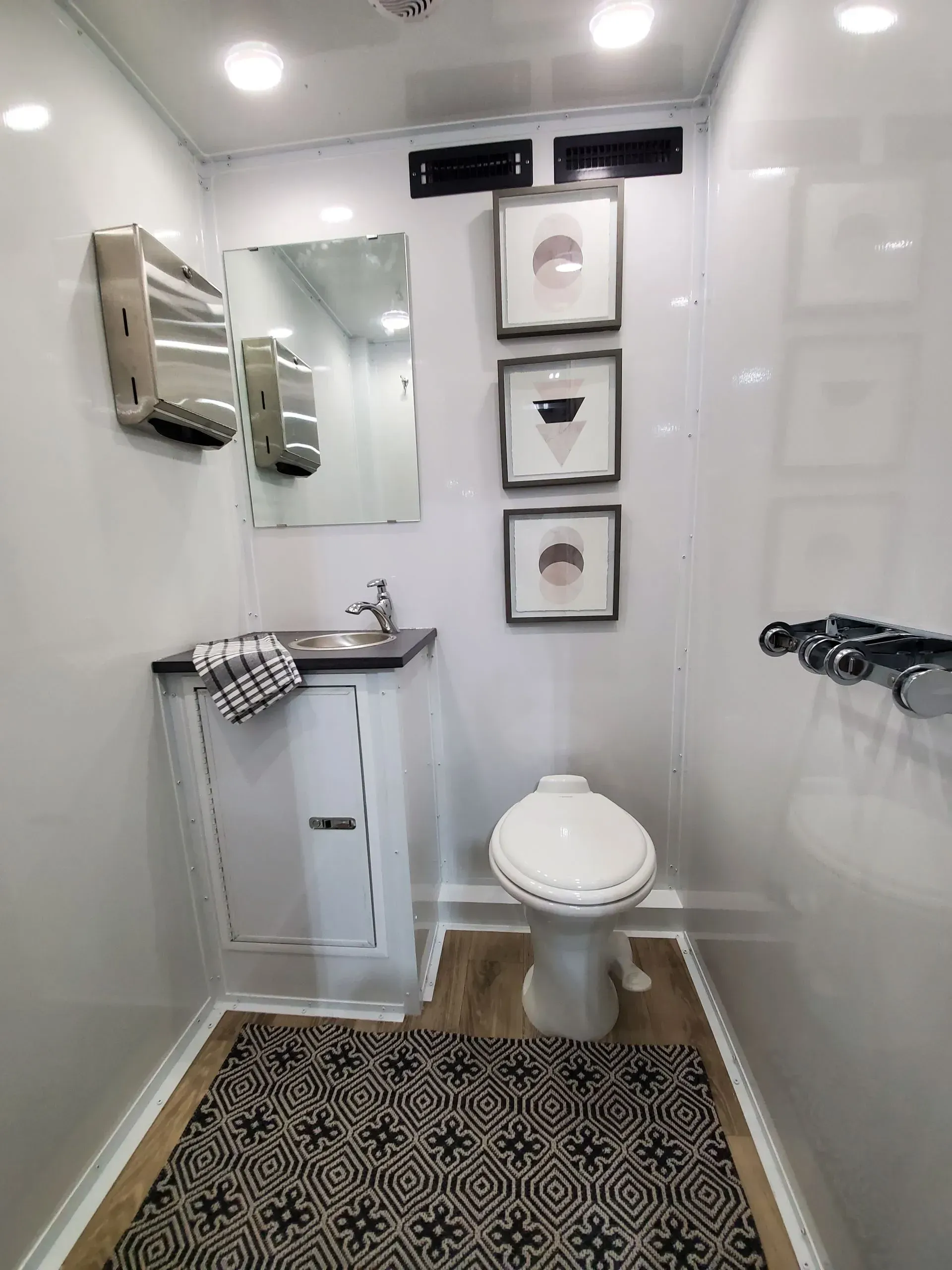 Luxury portable restroom interior with pedestal toilet, sink, mirror, and decorative artwork in Orange County porta potty rental Luxury portable restroom interior with pedestal toilet, sink, mirror, and decorative artwork in Orange County porta potty rental