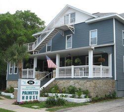 Palmetto House in Florida, blue building with porch, white stairs, sign, and US flag.