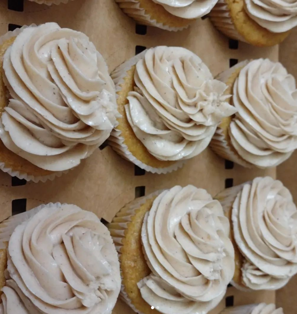 A bunch of cupcakes with white frosting on them