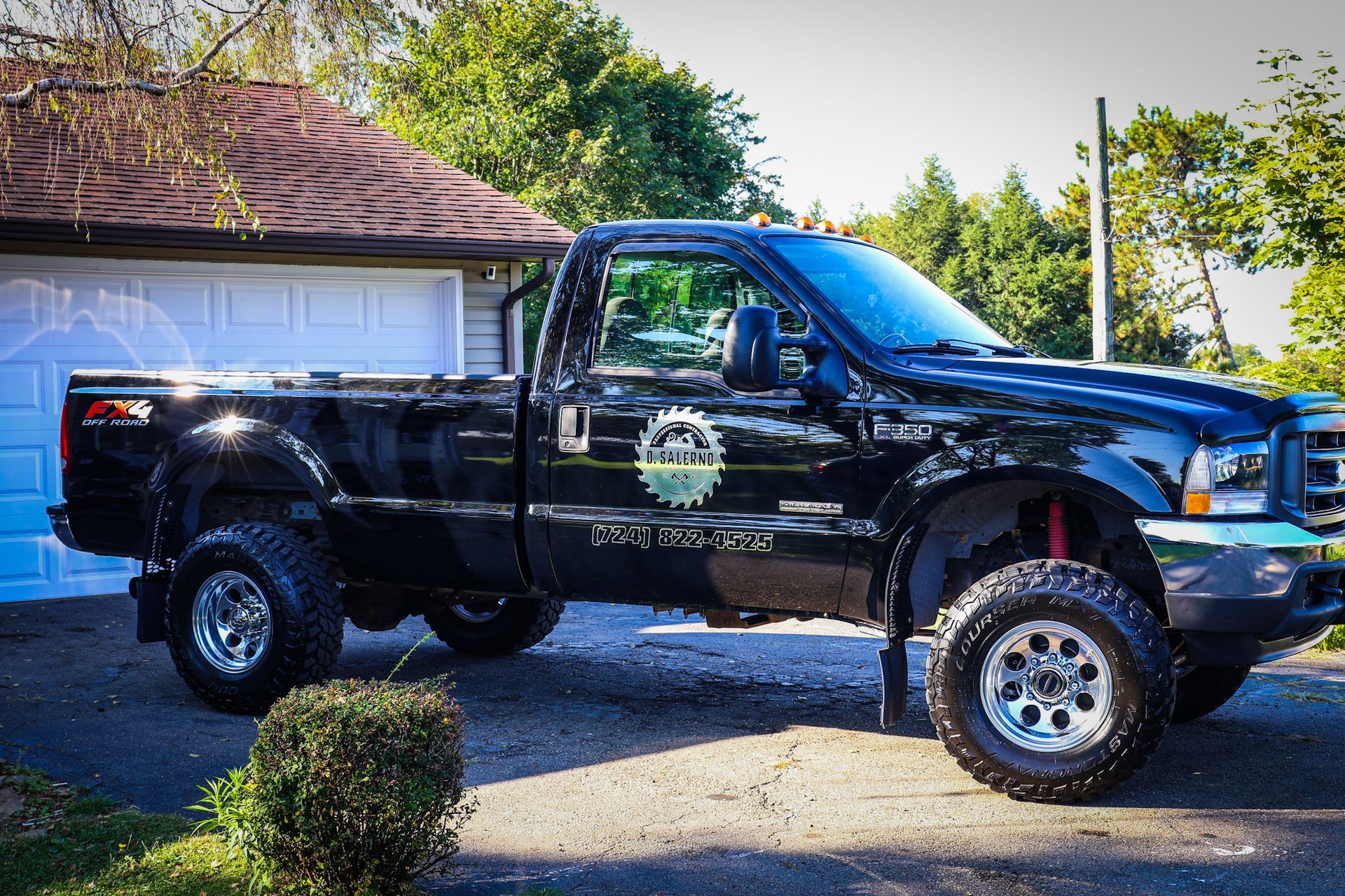 a red ford bronco is parked in front of a house .