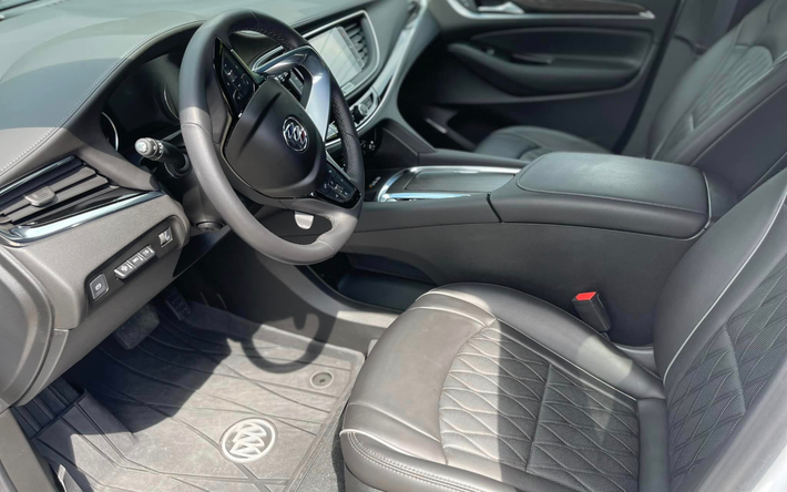 the interior of a white car with black seats and a steering wheel