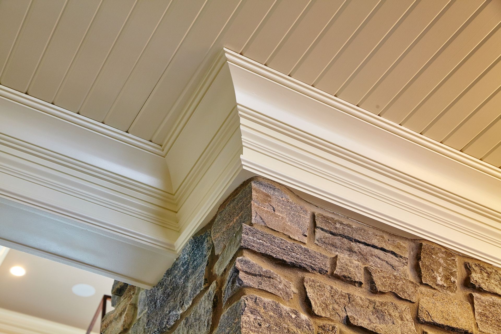 Stone wall corner with white trim and a ribbed ceiling.