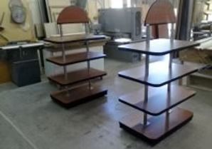 Two multi-tiered display shelves in a workshop setting, brown and silver.