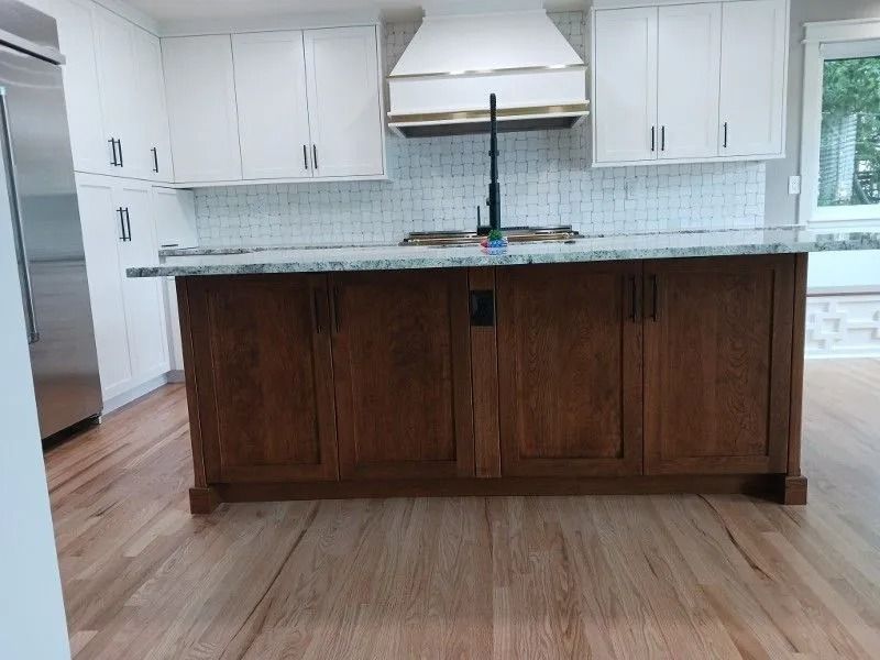 Kitchen with white cabinets, wood island, and light wood floors.