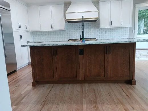 Kitchen with white cabinets, wood island, and light wood floors.