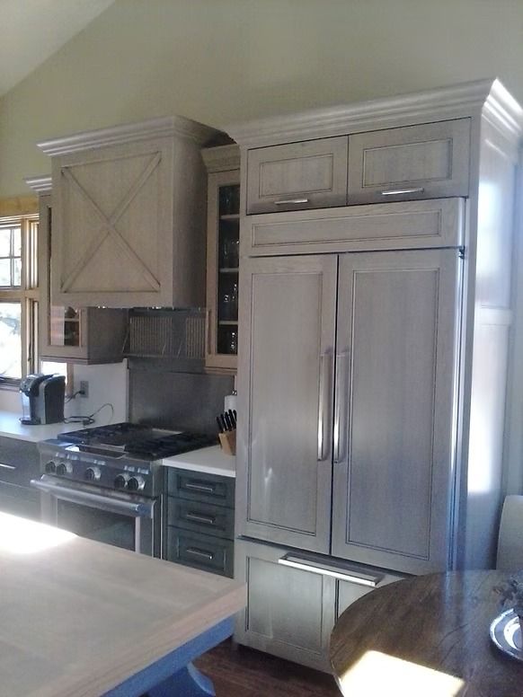 Gray kitchen with refrigerator, cabinets, stove, and island.