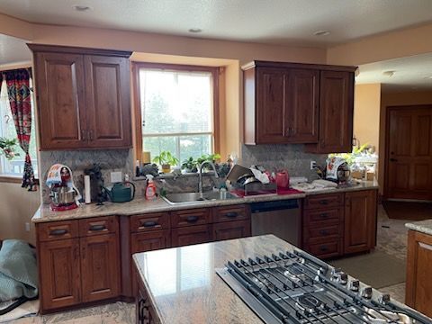 Dark wood cabinet with glass shelves, lit from within, against a red and dark wood paneled wall.