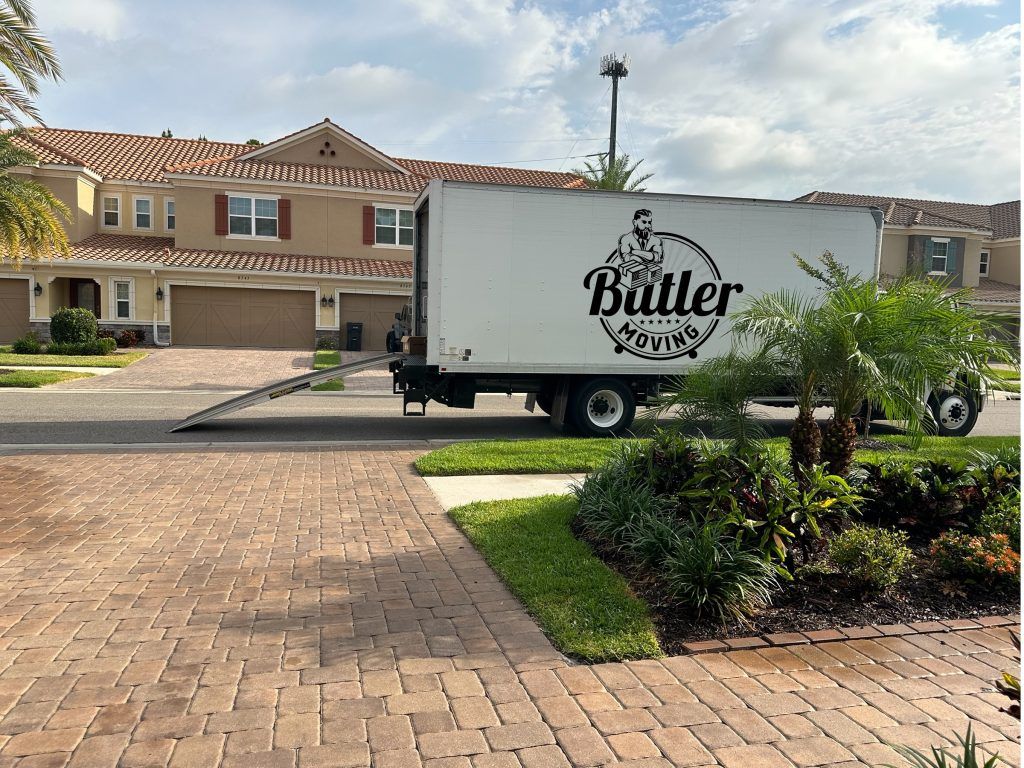 A butler moving truck is parked in front of a house