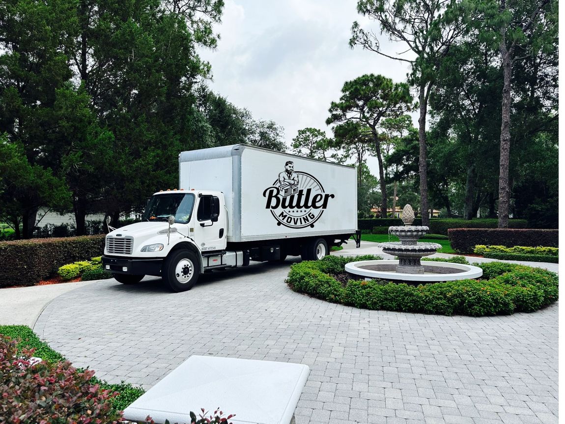 A white butler truck is parked in a driveway