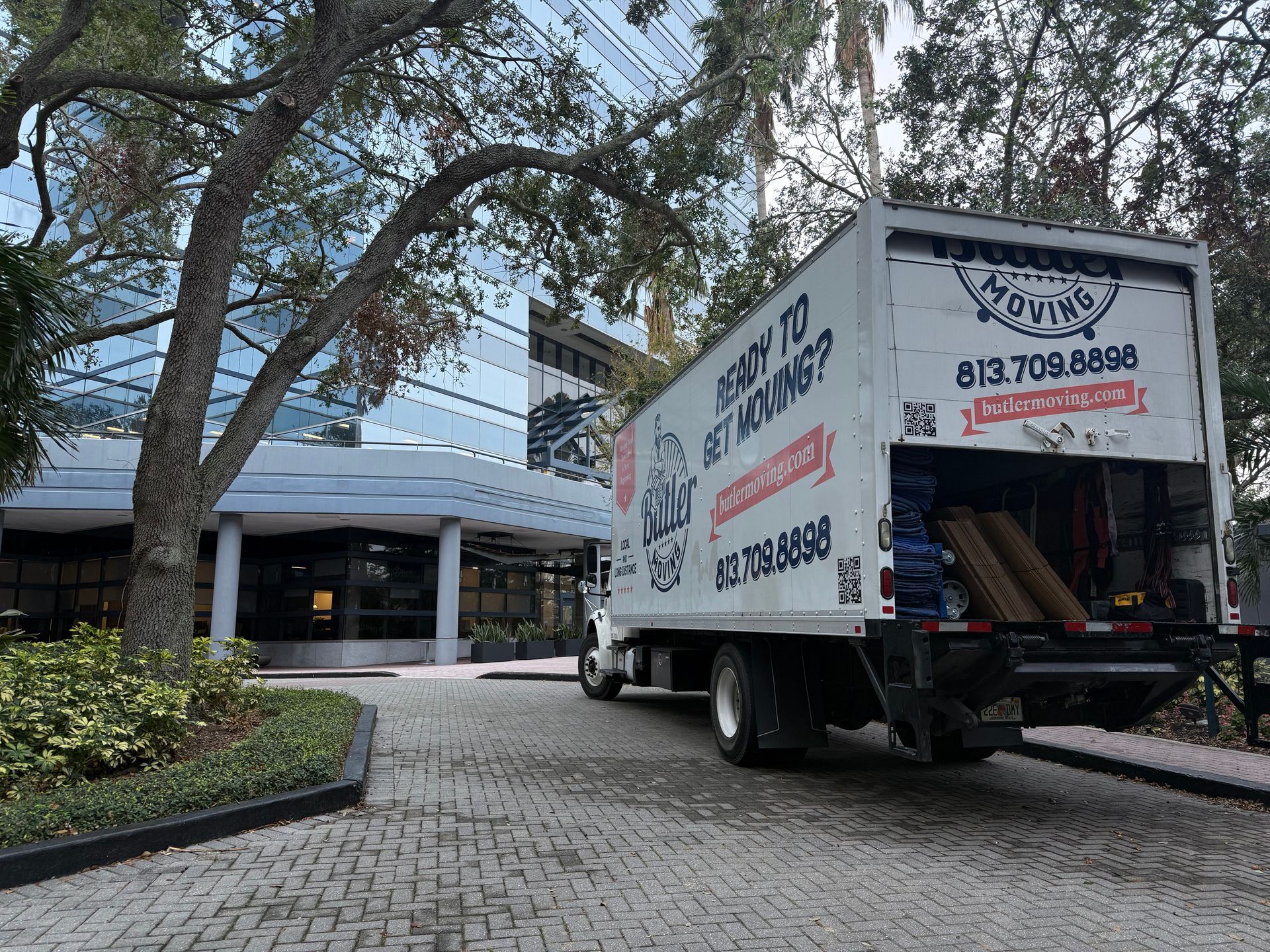 A moving truck is parked in front of a building.