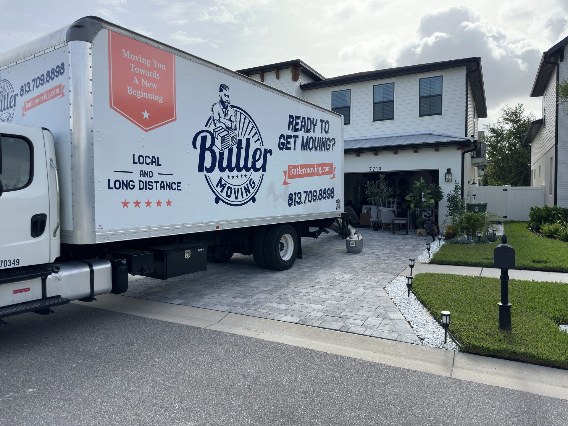 A moving truck is parked in front of a house.