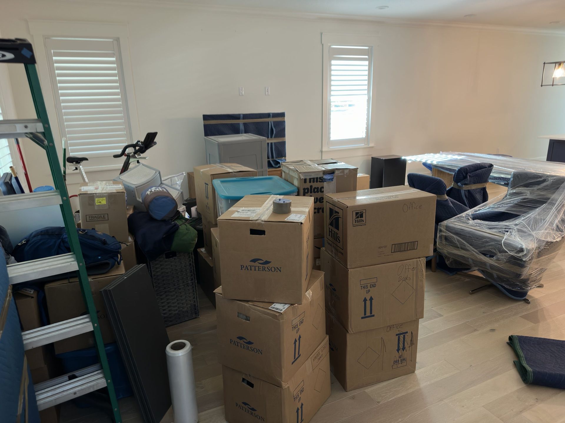 A living room filled with furniture wrapped in plastic wrap.