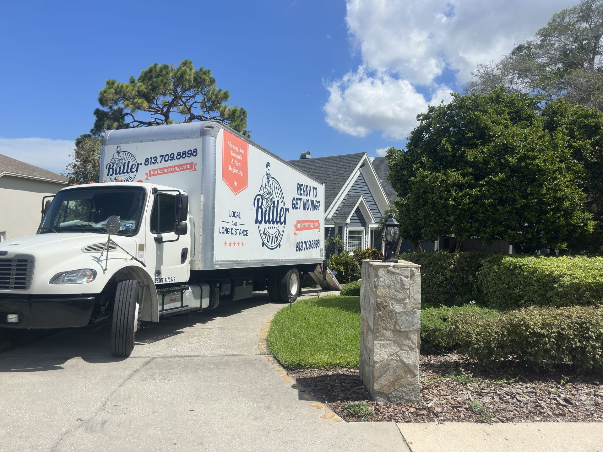 A moving truck is parked in front of a house.