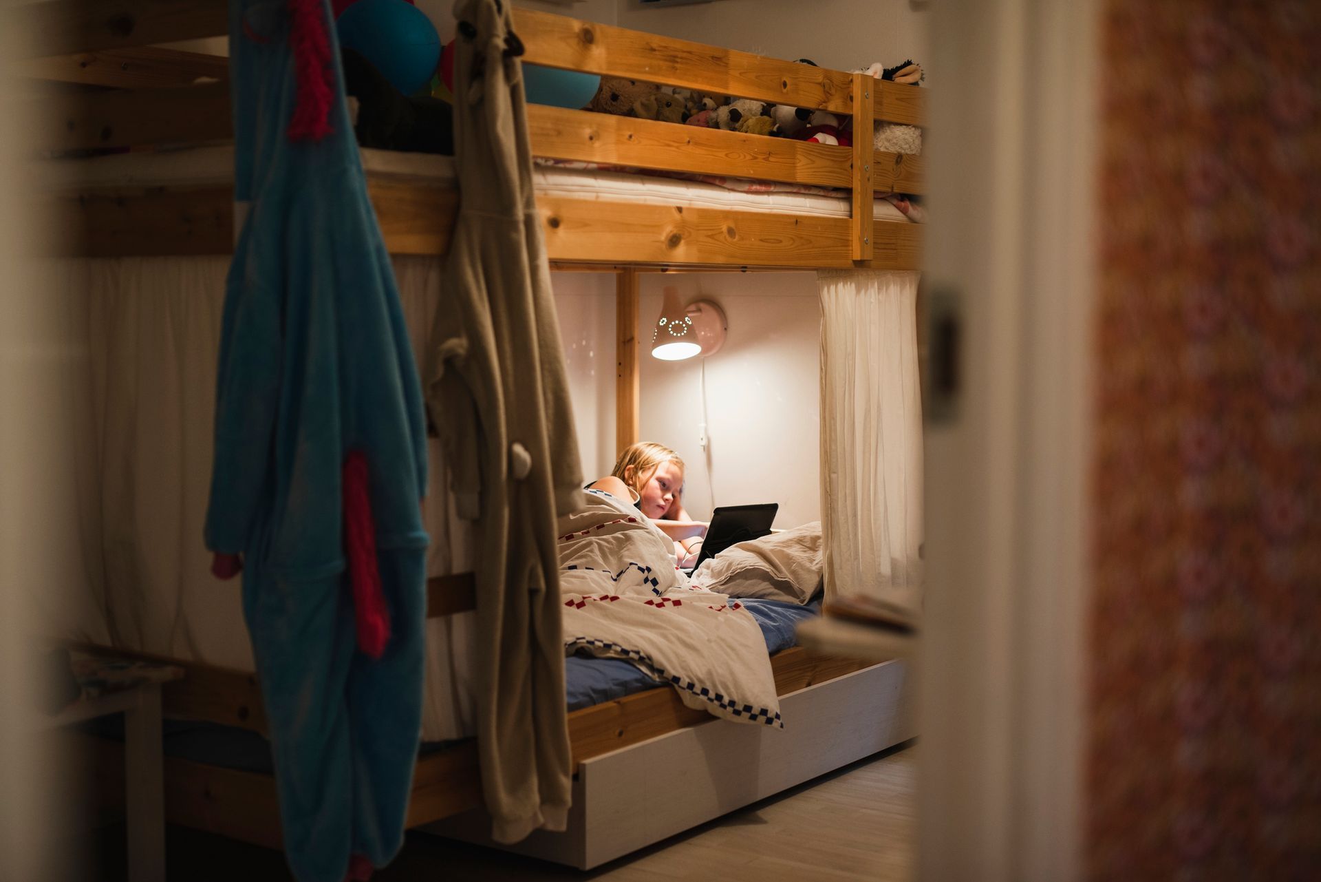 Persona a letto sotto il letto a castello che usa un computer portatile.