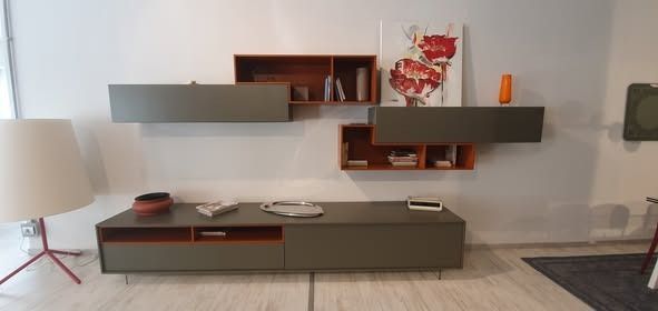 Soggiorno moderno con mensole sospese e console per l'intrattenimento. Toni grigi e arancioni, lampada a sinistra.