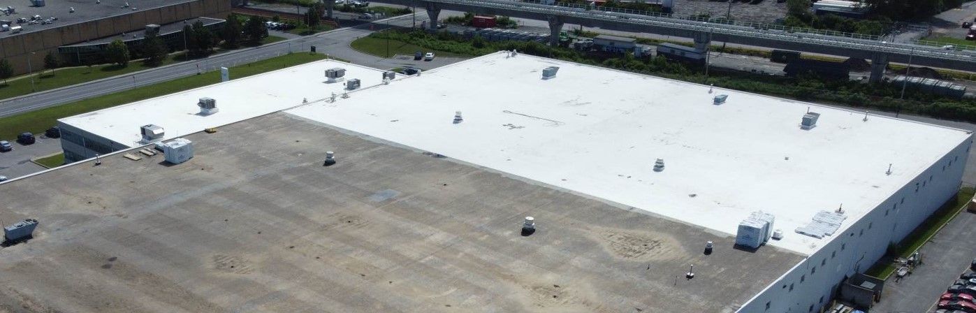 Une vue aérienne d'un grand bâtiment avec un toit blanc.