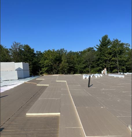 Un grand toit avec un ciel bleu et des arbres en arrière-plan