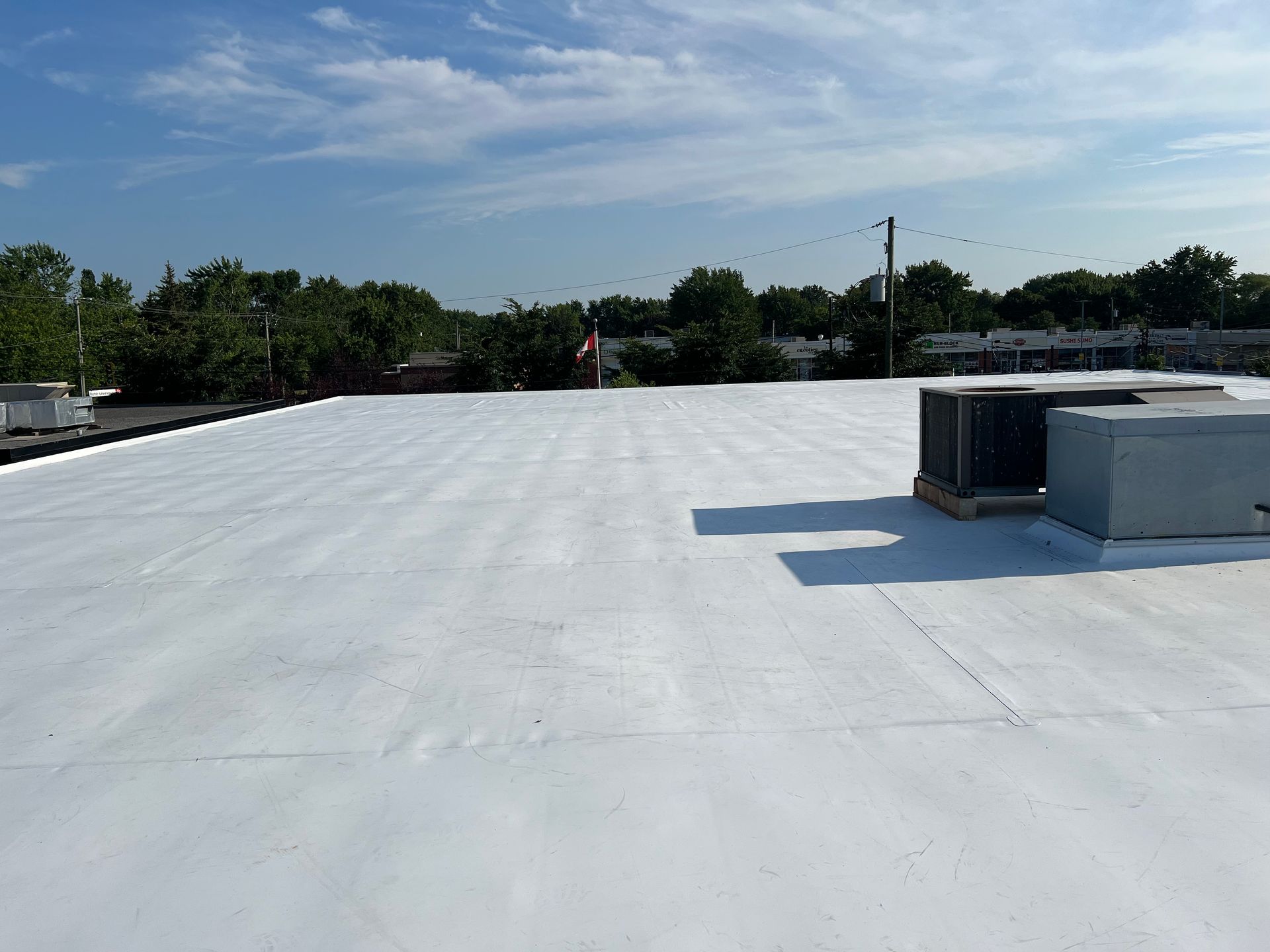 Un toit blanc avec quelques climatiseurs dessus.