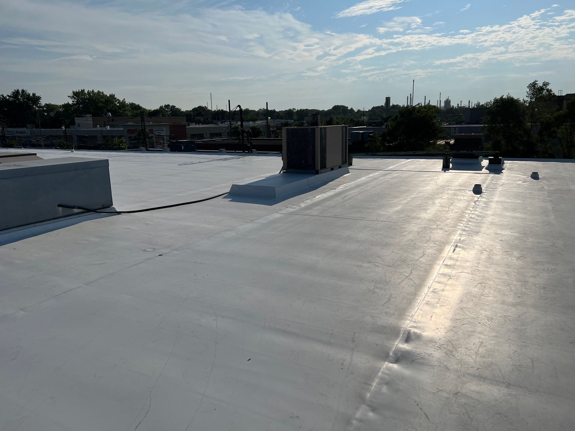 Un toit blanc avec une cheminée au-dessus.