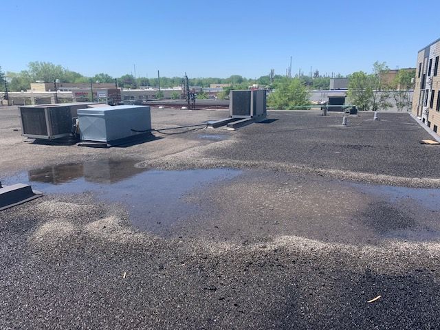 Le toit d'un bâtiment a une flaque d'eau dessus
