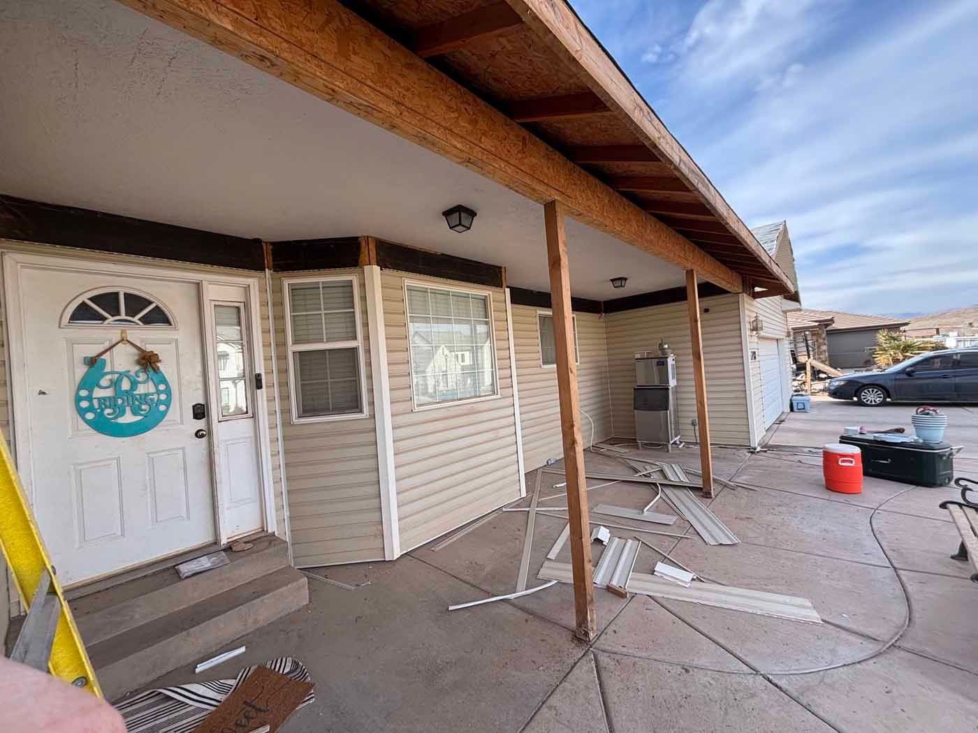 A person is standing in front of a house that is being remodeled.