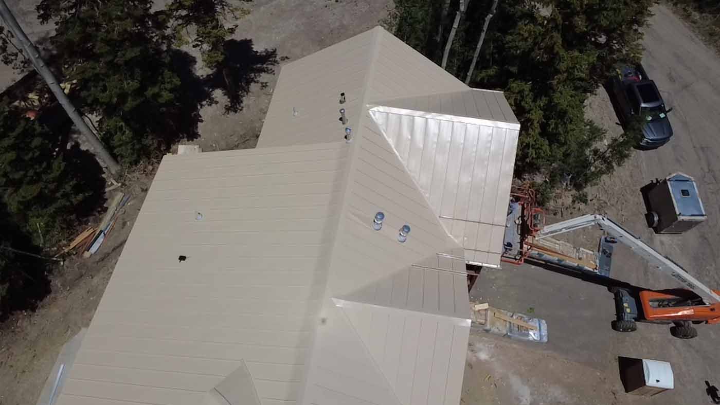 An aerial view of a house under construction with a crane on the roof.