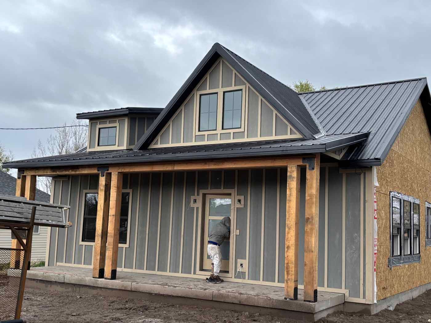 A man is standing in front of a house that is being built.