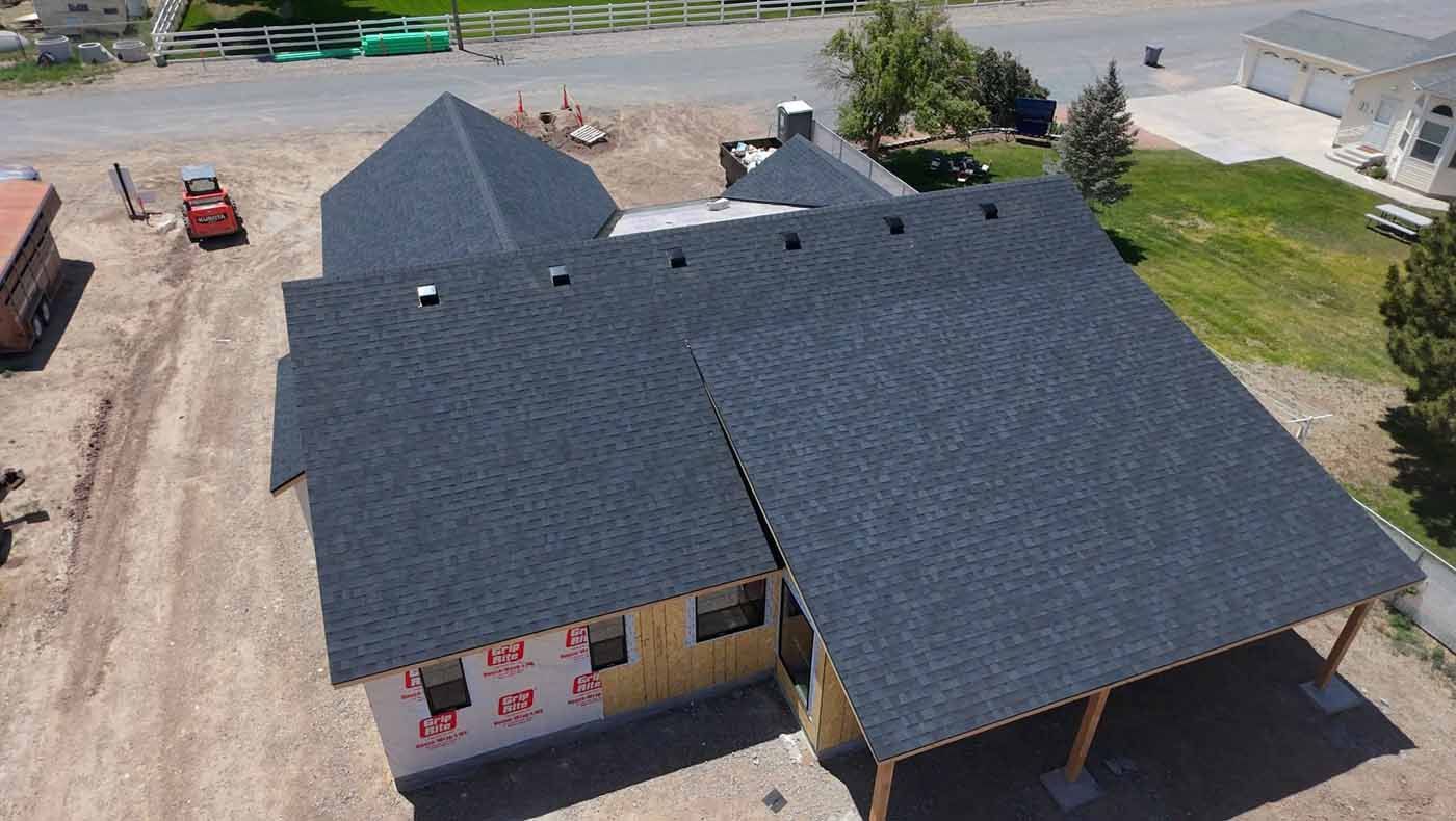 An aerial view of a house under construction with a black roof.