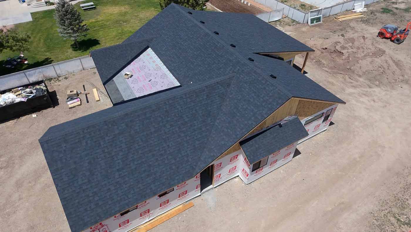 An aerial view of a house under construction with a black roof.