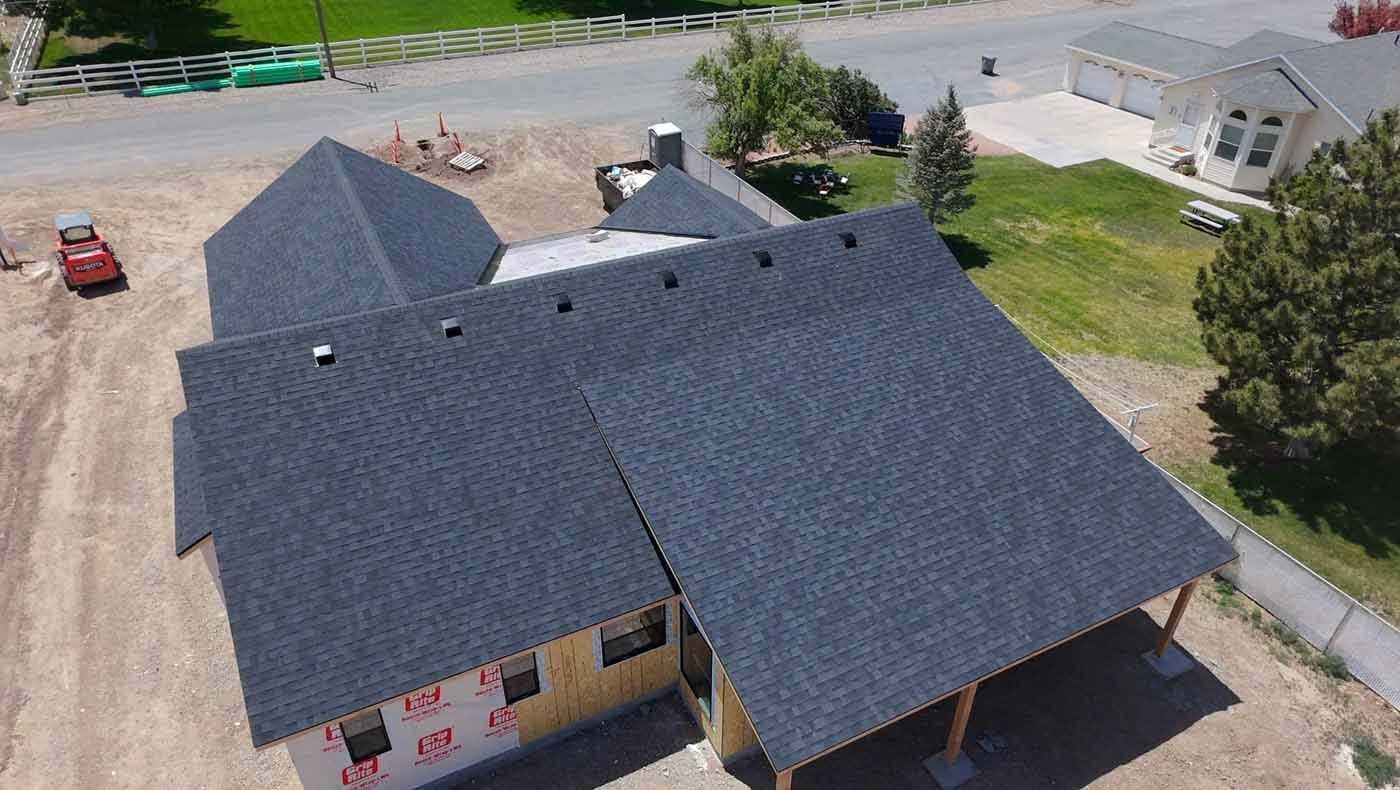 An aerial view of a house under construction with a black roof.