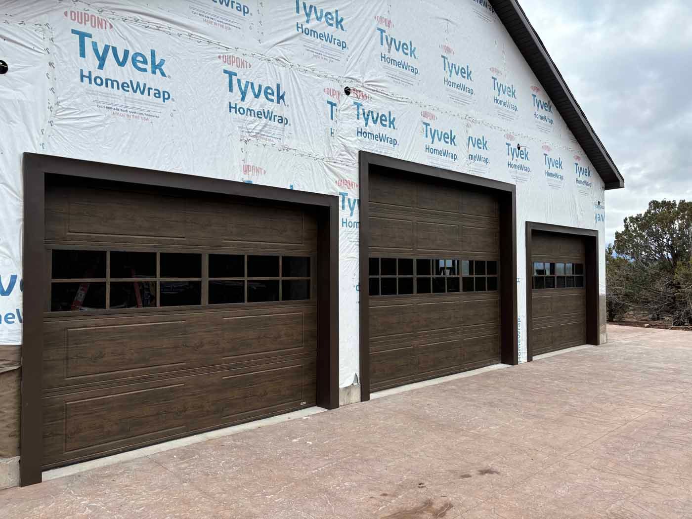 A row of garage doors are lined up on the side of a building.