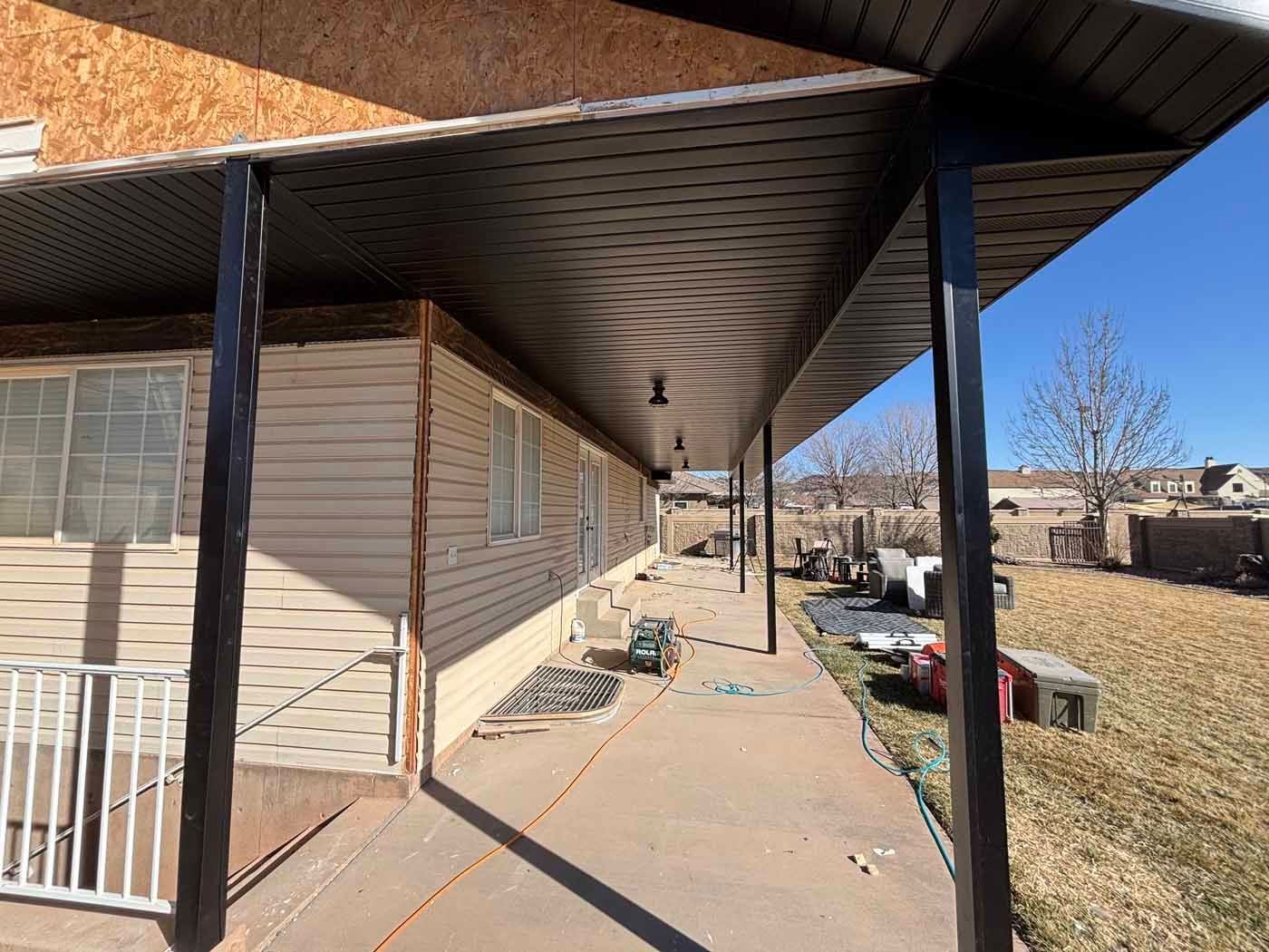 A house with a porch and a covered walkway leading to it.
