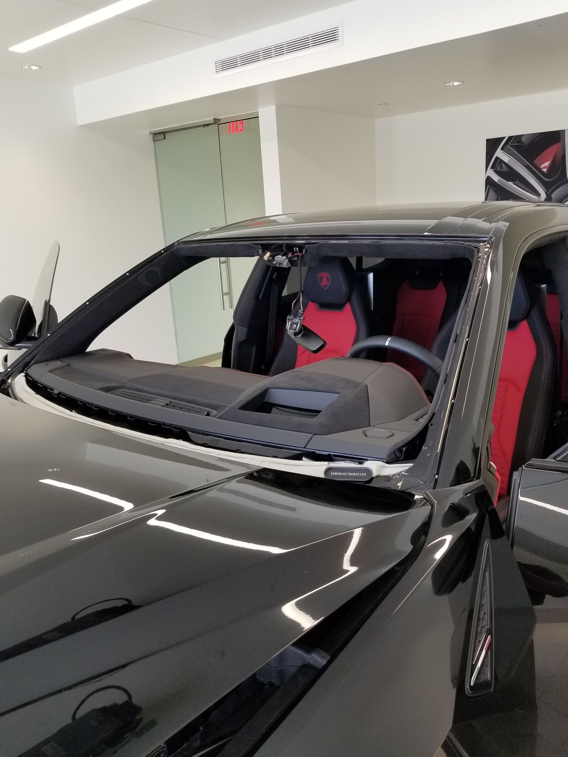 Black sports car interior with red seats on display in a showroom.