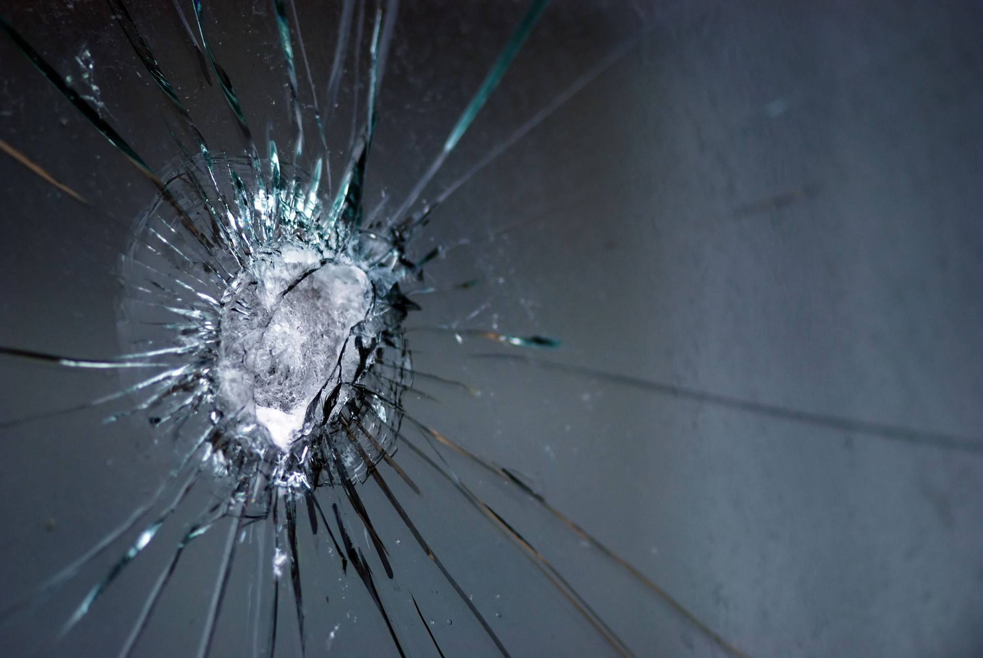 Shattered glass with a central impact point and radiating cracks.
