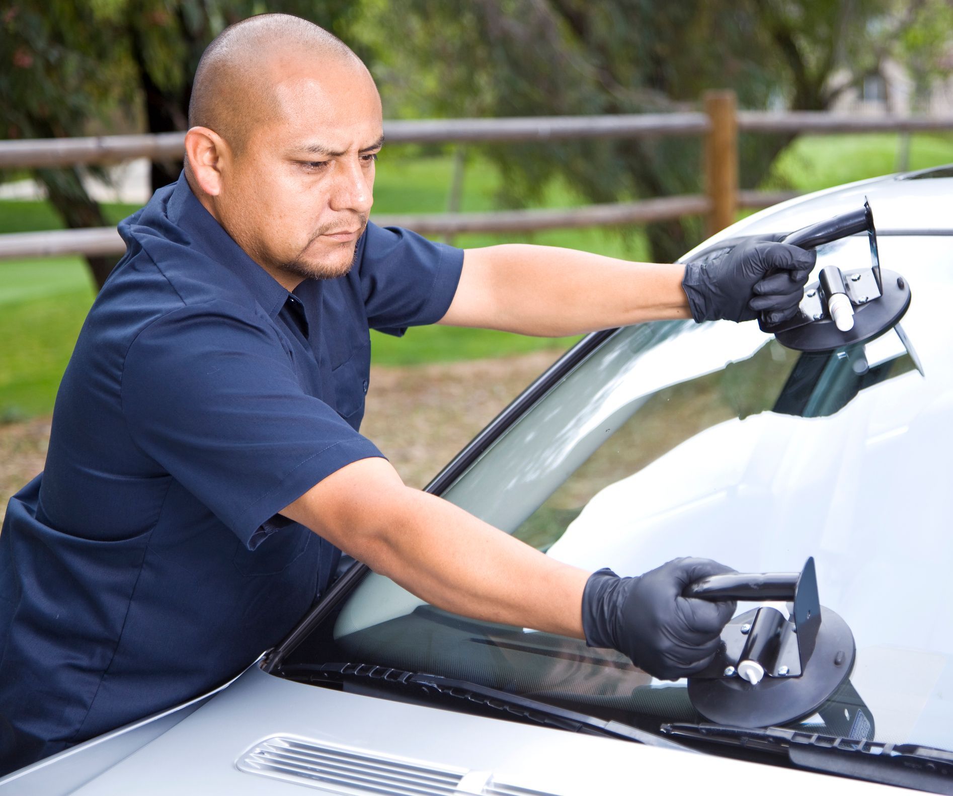 A technician examines a windshield, ensuring top quality for auto windshield replacement.