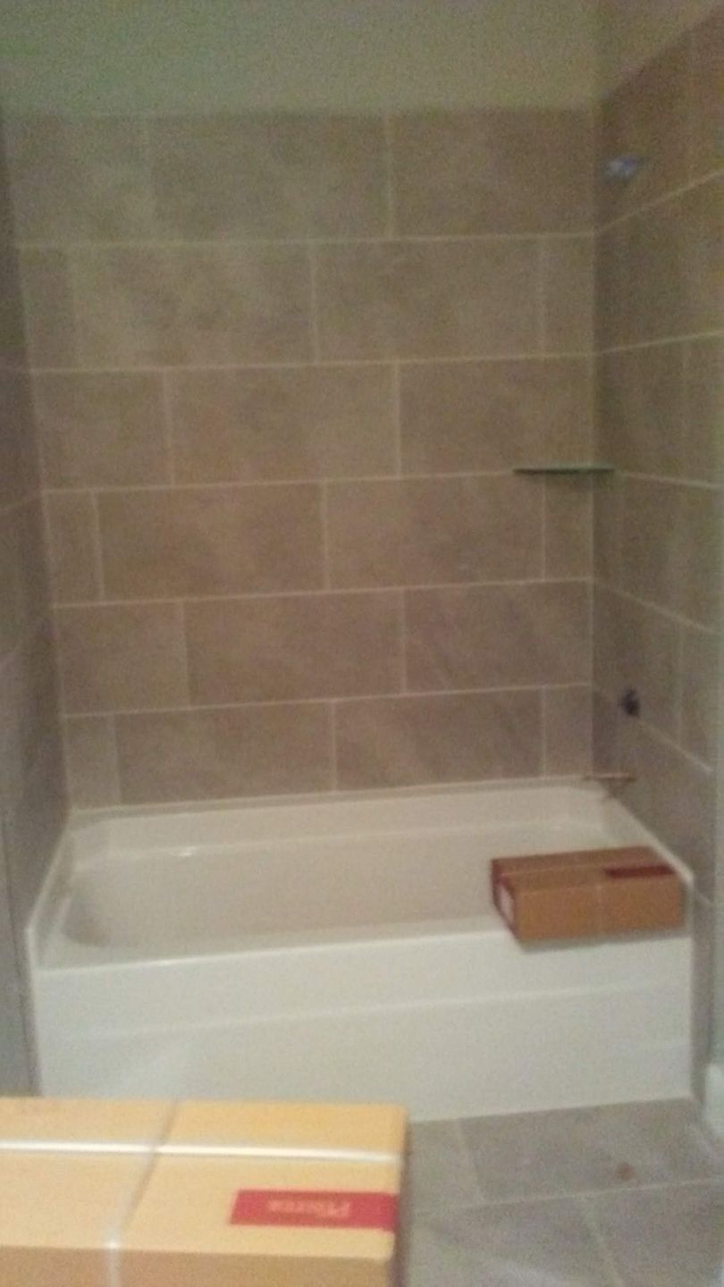 A bathroom with a bathtub and a box on the floor.