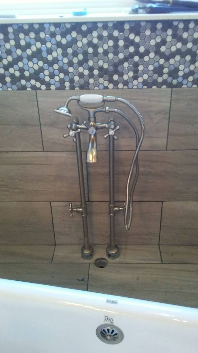 A bathroom with a bathtub and a shower head.