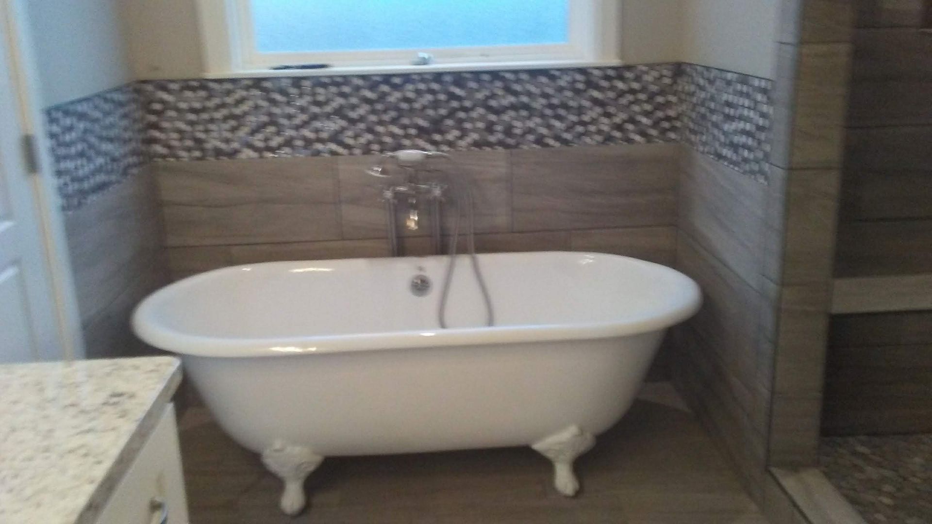 A bathtub is sitting in a bathroom next to a window.