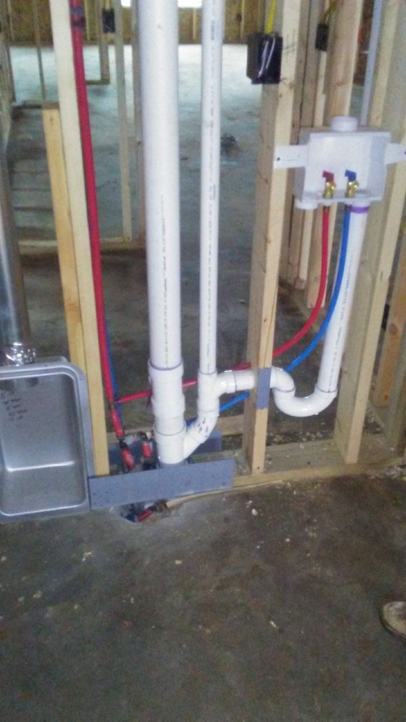 A bathroom sink is being installed in a house under construction.