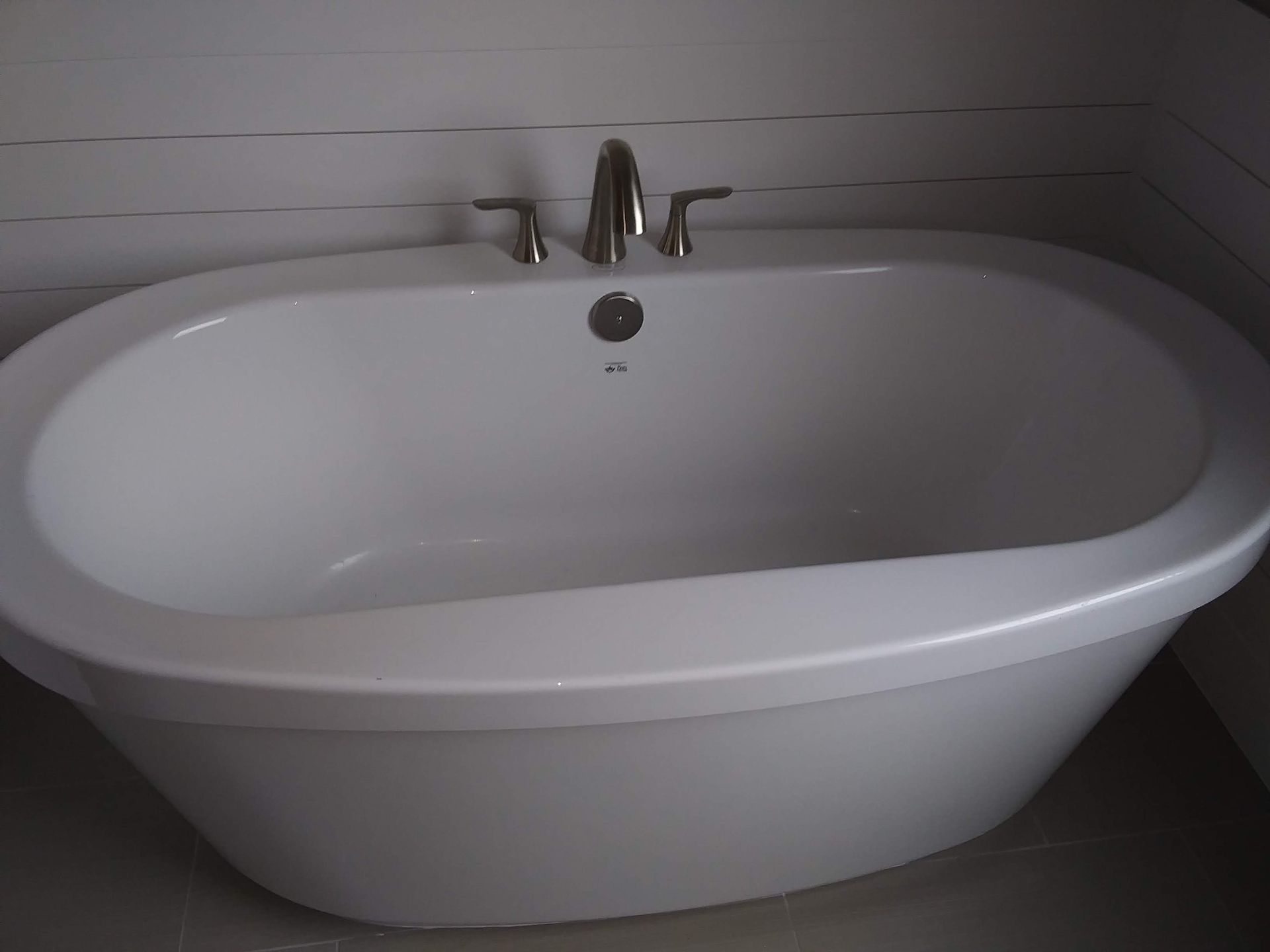 A white bathtub in a bathroom with a faucet