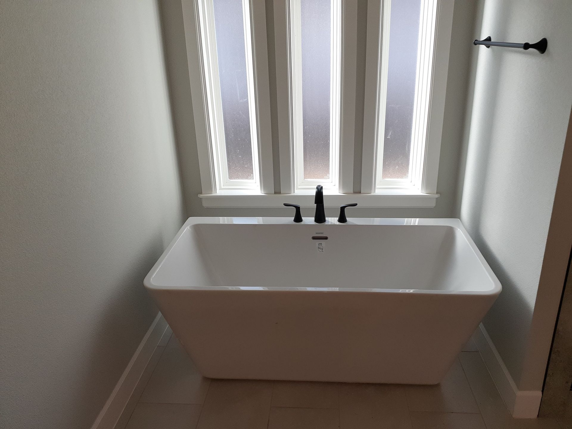 A bathtub in a bathroom next to a window