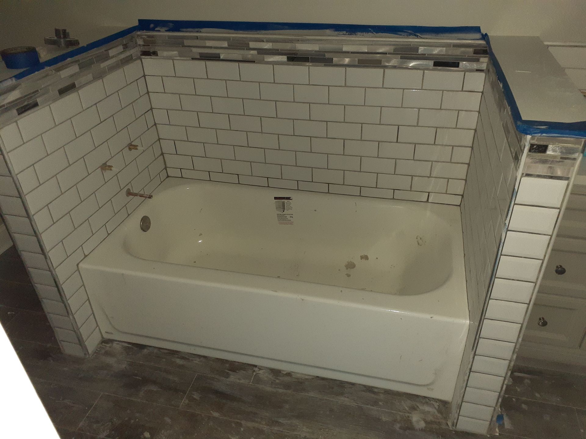A bathtub surrounded by white bricks in a bathroom