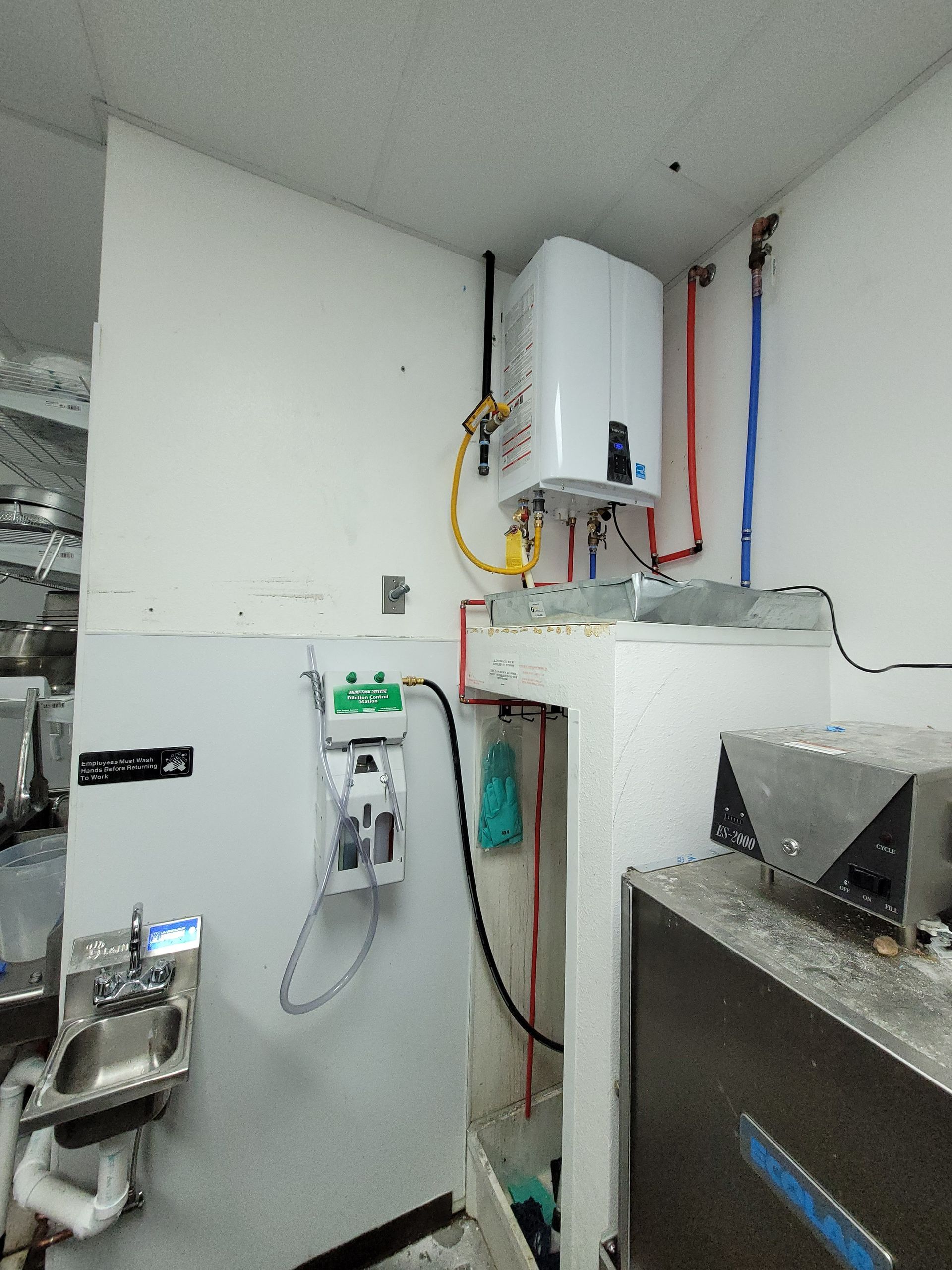 A kitchen with a sink and a heater on the wall