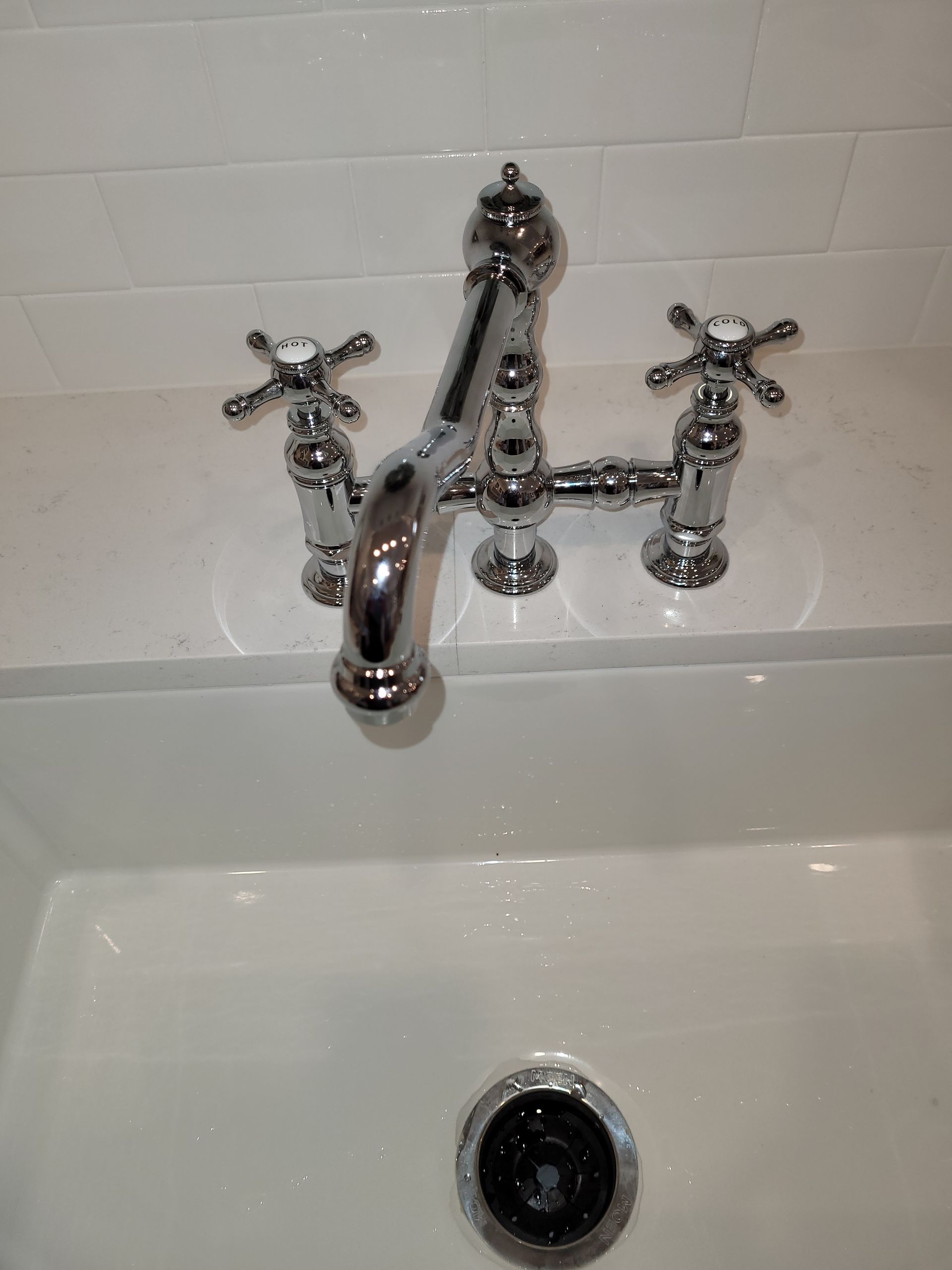 A bathroom sink with a chrome faucet and cross handles.