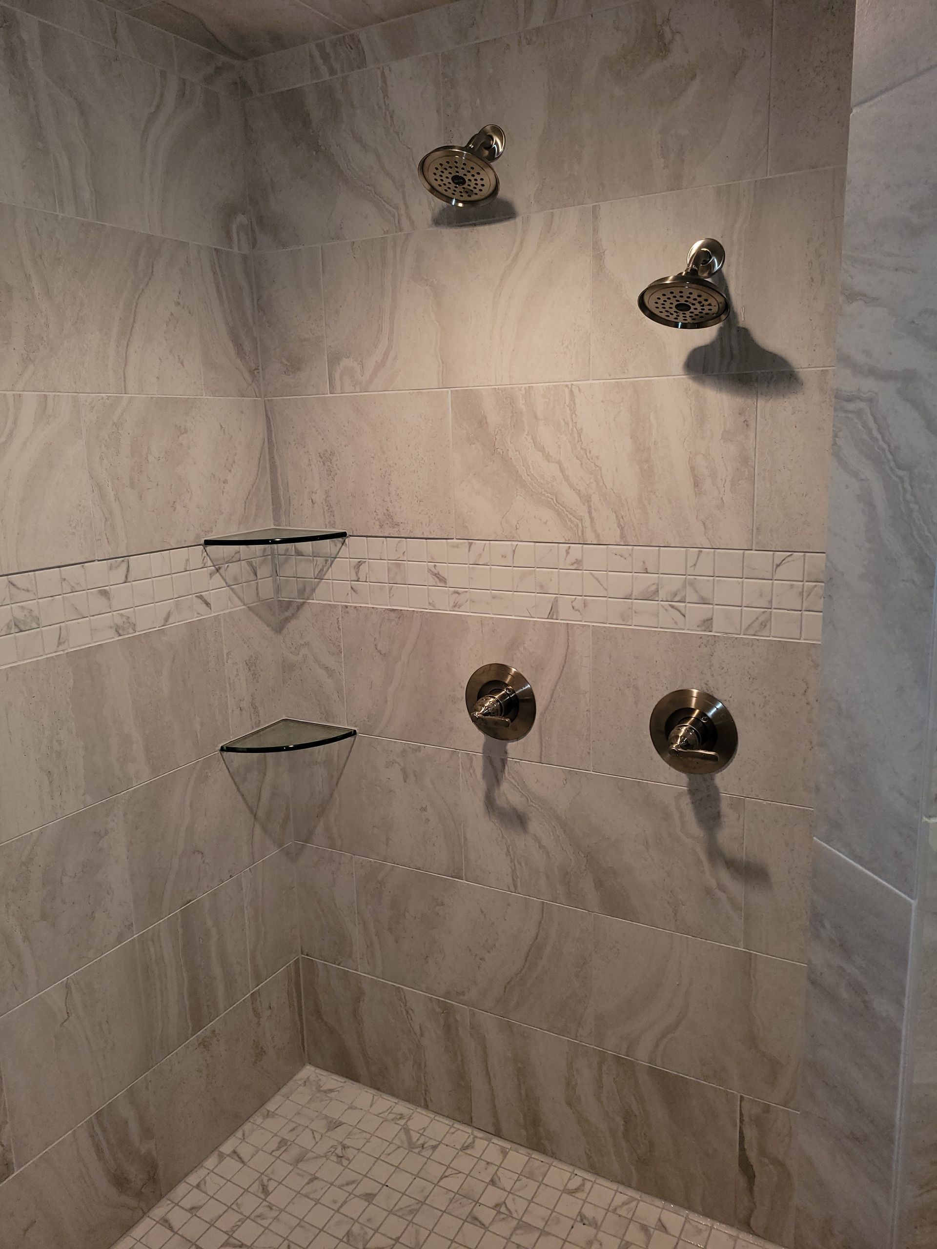 A bathroom with a walk in shower and a tiled wall.
